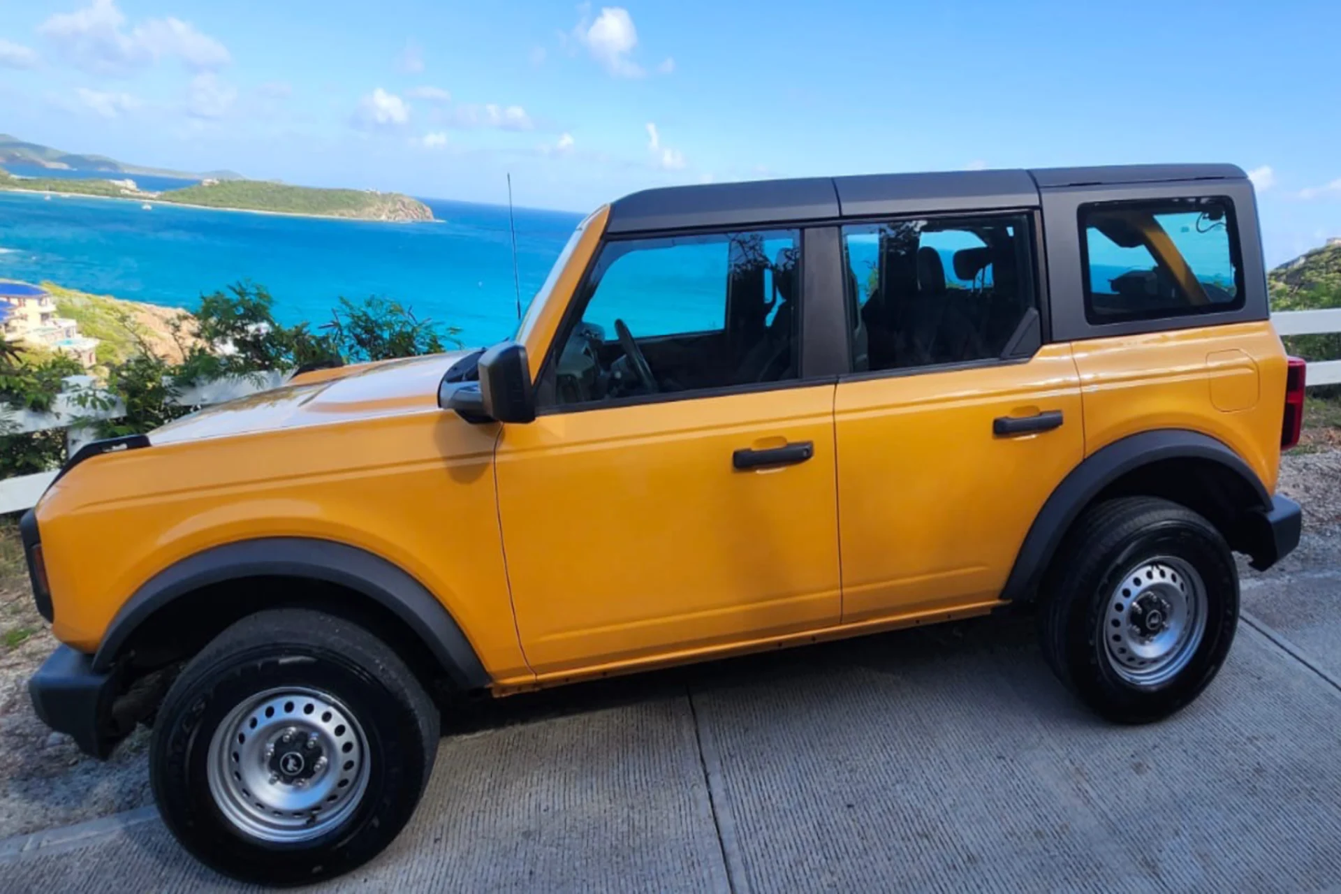 Yellow SUV parked overlooking blue ocean